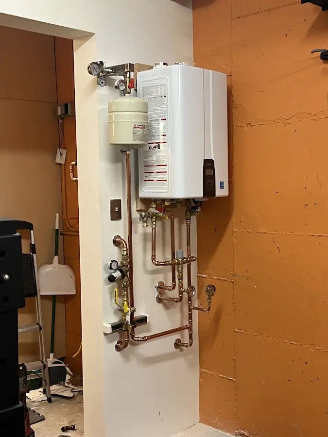 Plumbing technician inspecting water heater connections in Dunn